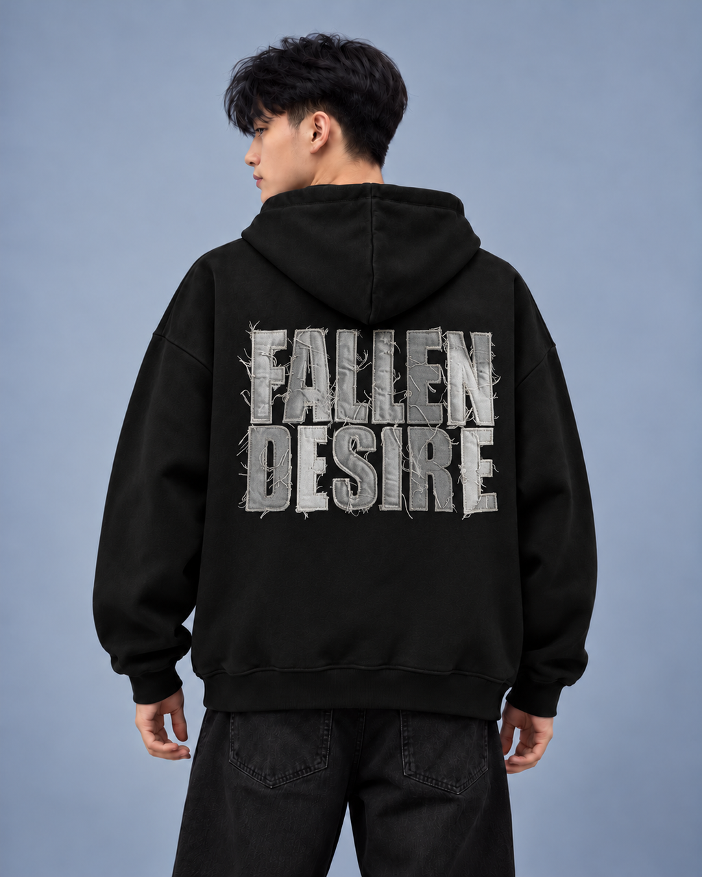 Fallen Desire black hoodie — model back on light grey studio background