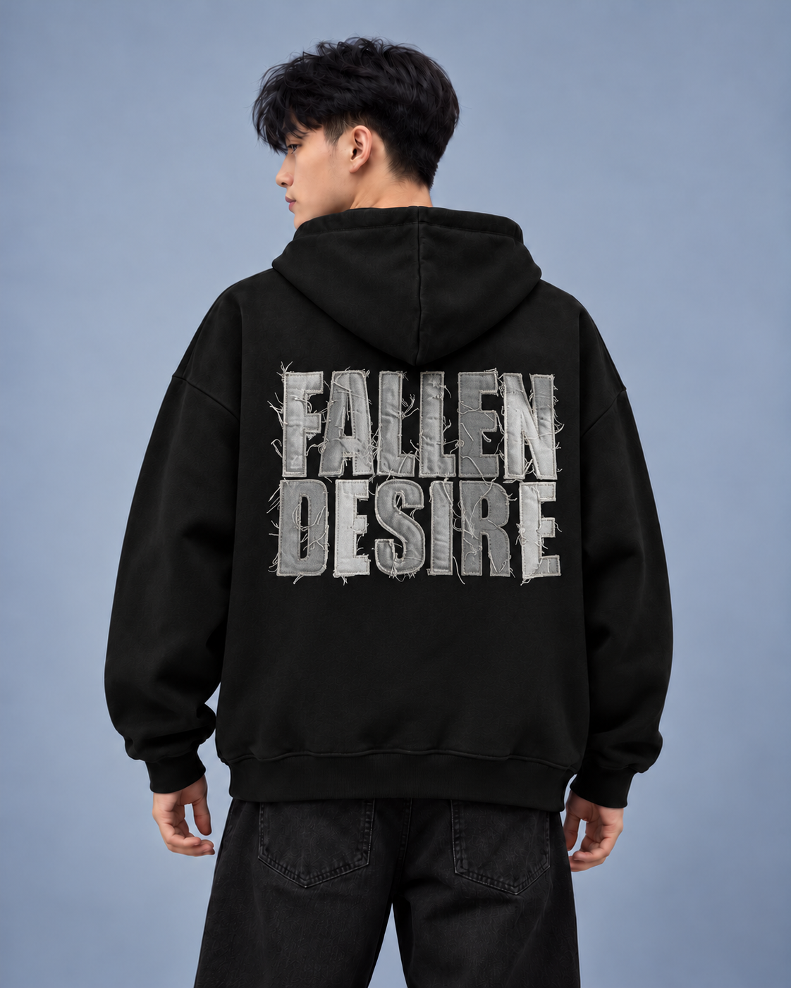 Fallen Desire black hoodie — model back on light grey studio background
