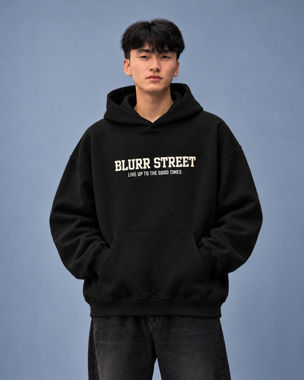 Street Soul black hoodie — model front on light slate-grey studio background
